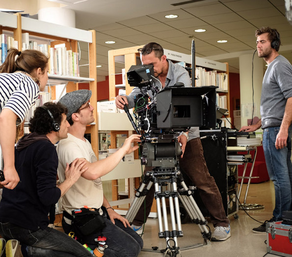 Perchman, caméraman et techniciens sur scène de tournage dans bibliothèque