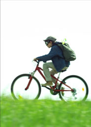Garçon sur un vélo qui roule dans l'herbe